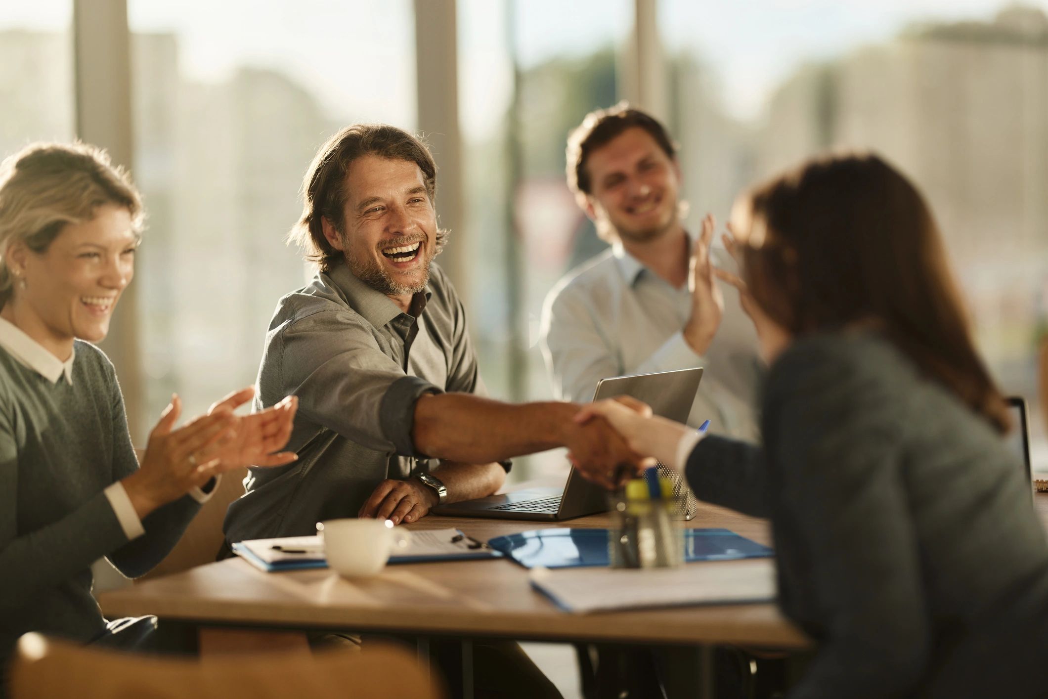 Recruitment team shaking hands with a candidate after a successful interview
