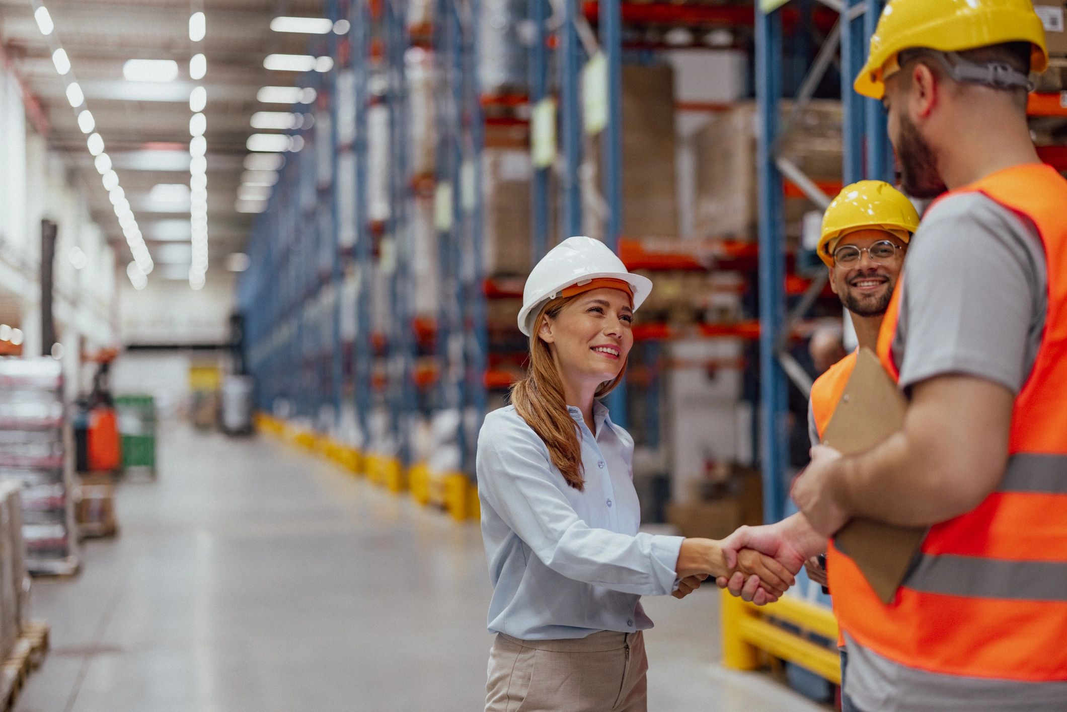 Warehouse manager shaking hands with worker after agreement