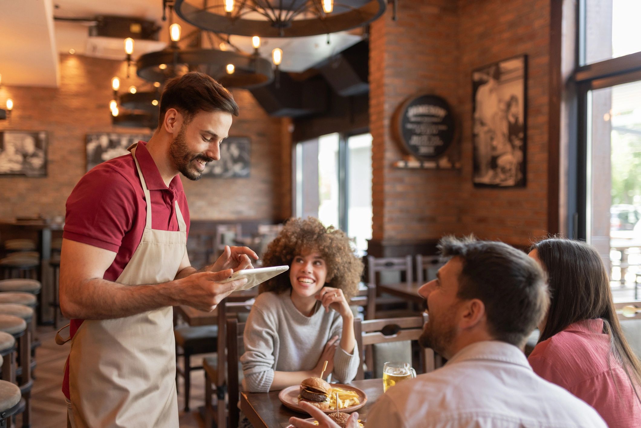 Waiter using a tablet to take an order in a restaurant